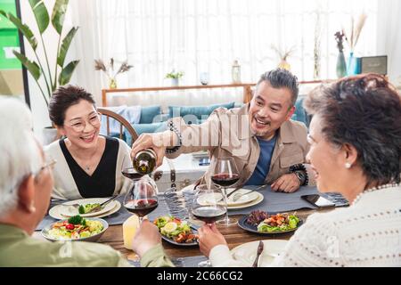 Glückliches altes Paar im Wohnzimmer, das zusammen speiend Stockfoto