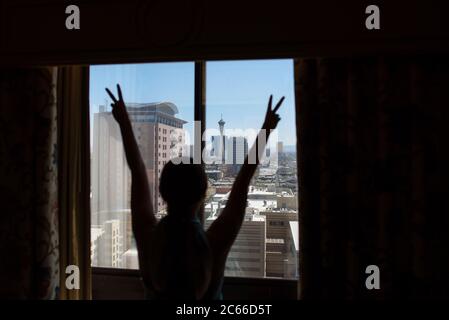 Frau, die die Aussicht vom Hotelzimmer genießt, Las Vegas, Nevada, USA Stockfoto