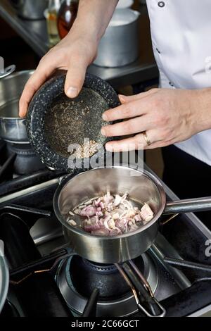 Prozessschritte für die Zubereitung einer Sauce Béarnaise, Zugabe von weißem Pfeffer Stockfoto