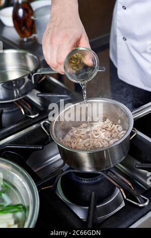 Zubereitung der Béarnaise Sauce Schritt für Schritt, Weißwein wird hinzugefügt Stockfoto