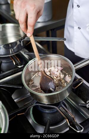 Zubereitung der Béarnaise Sauce Schritt für Schritt, Schalotten in den Topf gerührt Stockfoto