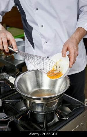 Zubereitung der Béarnaise Sauce Schritt für Schritt, Eigelb wird hinzugefügt Stockfoto