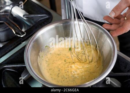 Zubereitung der Sauce Béarnaise Schritt für Schritt, Kerbel wird in die Sauce gegeben Stockfoto