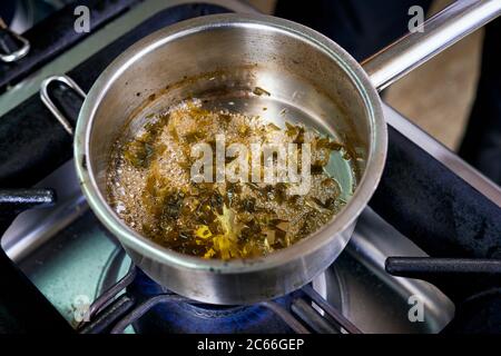 Zubereitung der Béarnaise Sauce Schritt für Schritt, Wein und Essig sowie Schalotten und Kräuter werden gekocht und reduziert Stockfoto