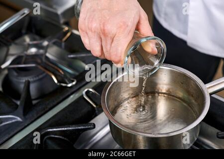 Zubereitung der Béarnaise Sauce Schritt für Schritt, Wasser und Wein werden erhitzt Stockfoto