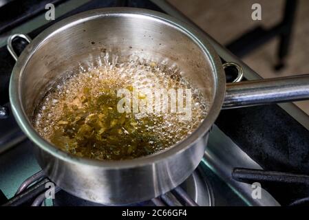 Zubereitung der Béarnaise Sauce Schritt für Schritt, Wein und Essig sowie Schalotten und Kräuter werden gekocht Stockfoto