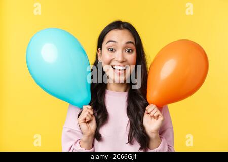 Menschen Emotionen, Lifestyle Freizeit und Beauty-Konzept. Fröhlich glücklich asiatische Mädchen mit großen Urlaub gratulieren, halten zwei Ballons und lächeln Stockfoto