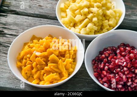 Zutaten für die Chutney-Zubereitung in weißen Schalen auf einem Holzbrett Stockfoto