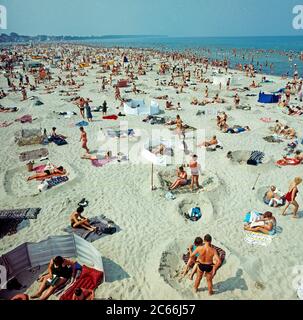 Sommerurlauber entspannen am breiten Sandstrand von Warnemünde an der Ostsee Stockfoto