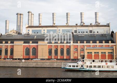 Moskau, Russland - 06. Juli 2020 Energieversorgungsunternehmen, Rauschskaja Naberezhnaya GES 1. Das Motorschiff schwimmt am ältesten Kraftwerk der MOSC vorbei Stockfoto