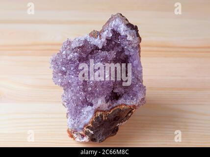 Natürlicher Amethyst Stein Cluster isoliert auf Holzhintergrund Stockfoto