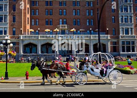 Eine Kutsche, die vor dem berühmten Empress Hotel am Wasser in Victoria British Columbia, Kanada, fährt. Stockfoto