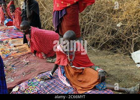 MASAI MARA, KENIA - 23. AUG 2010: Lokale Verkäufer aus dem Stamm der Masai bieten Waren auf dem Markt an. Traditionelle handgemachte Accessoires sehr beliebtes Souvenir fro Stockfoto