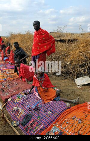 MASAI MARA, KENIA - AUG 23: Lokale Verkäufer aus dem Stamm der Masai bieten am 23. Aug 2010 in Masai Mara Waren auf dem Markt an. Traditionelle handgefertigte Accessoires Stockfoto