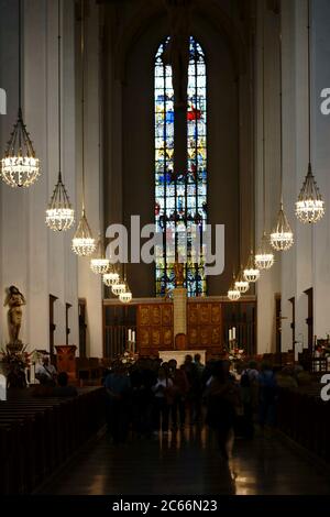 Besucher und Touristen besuchen den Altar und das Innere der Frauenkirche oder des Doms in München, Stockfoto