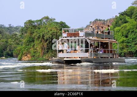 UGANDA - AUG 27, 2010: Touristen besuchen die Murchison Falls, auch bekannt als Kabarega Falls, ist ein Wasserfall zwischen dem Lake Kyoga und dem Lake Albert on the Whit Stockfoto