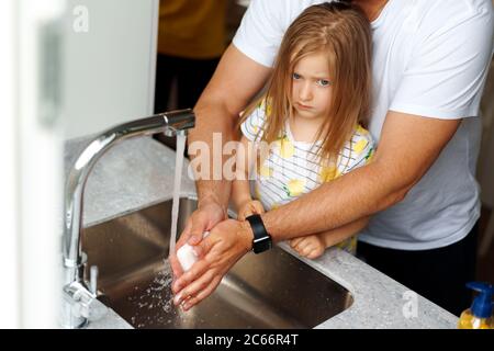 Vater und Tochter waschen sich die Hände über dem Waschbecken in einer Küche Stockfoto