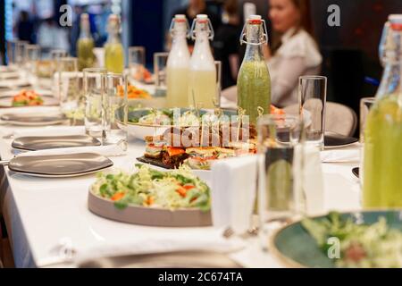 Tisch während einer Rezeption in einem Restaurant. Sichtbares Gesicht verändert und verschwommen, getönt Stockfoto