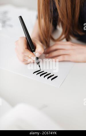Nahaufnahme Foto von Frau Hände halten Stift und Schreiben auf Papier isoliert Stockfoto