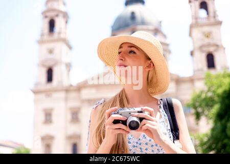 Portrait Aufnahme der schönen blonden Frau halten Kamera in den Händen, um Fotos in der Stadt. Stockfoto