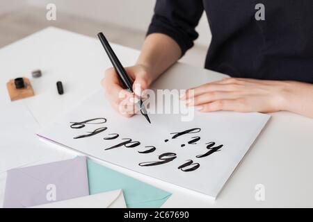 Portrait der jungen Frau Hände schreiben Alphabet auf Papier auf Schreibtisch isoliert Stockfoto