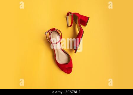 Rote Damenschuhe auf gelbem Hintergrund. Flach liegend, Draufsicht. Beauty Blog Konzept. Stockfoto