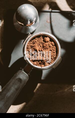 Gemahlener Kaffee in einem Portafilter und einer Kaffeepulver. Stockfoto