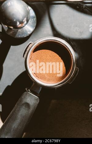 Gemahlener Kaffee in einem Portafilter und einer Kaffeepulver. Stockfoto
