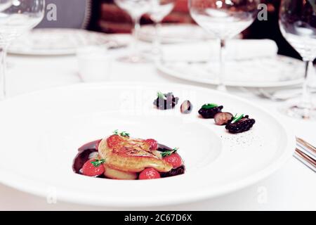 Foie Gras mit Portosoße auf dem Tisch in einem teuren französischen Restaurant, getönt Stockfoto