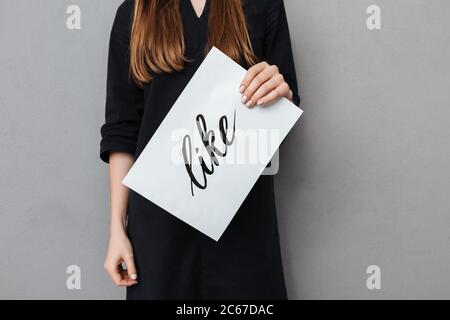 Nahaufnahme Foto von Frau Körper stehend und halten Postkarte auf grauem Hintergrund Stockfoto