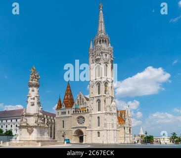 Budapest, Ungarn - 27. juni 2020 - Außenansicht der Matyas-Kirche, mit der Szentharomsag-szobor (Heilige Dreifaltigkeitsstatue) vor der Kirche Stockfoto