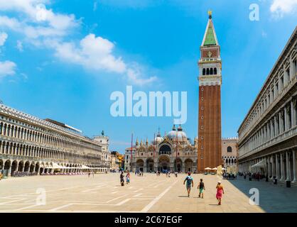 Venedig, Italien - 29. juni 2020 - sehr wenig Touristen überqueren den Markusplatz mit dem Markusturm (Loggetta del Sansovino) und Th Stockfoto