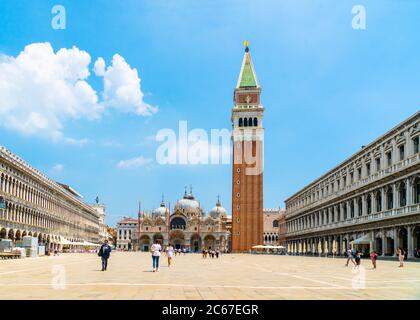 Venedig, Italien - 29. juni 2020 - sehr wenig Touristen überqueren den Markusplatz mit dem Markusturm (Loggetta del Sansovino) und Th Stockfoto