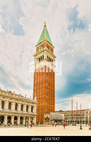 Venedig, Italien - 29. juni 2020 - sehr wenig Touristen überqueren den Markusplatz mit dem Markusturm (Loggetta del Sansovino) auf einer s Stockfoto