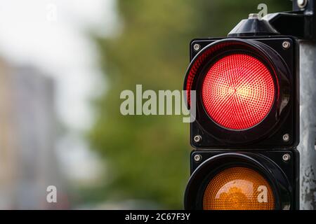 Verkehrssteuerungs-Semaphore mit Stoppleuchte auf unfokussem Stadthintergrund Stockfoto