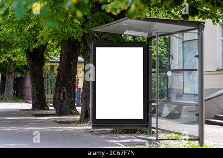 Weißes leeres Werbebanner an einer Haltestelle des öffentlichen Verkehrs eines Trolleybusses in der Stadt in der Nähe des Parks Stockfoto