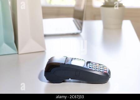 NFC-Bezahlterminal auf einem weißen Tisch. Kreditkarte oder Telefon Pay POS Bankgerät, Kartenautomat. Stockfoto