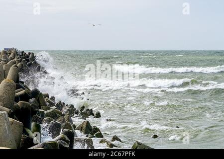 Blick auf die stürmische Ostsee, Wellen plätschern gegen die Betonpier Stockfoto