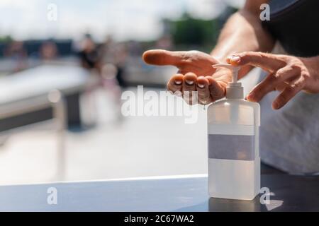 Person, die in der Öffentlichkeit Handdesinfektionsmittel verwendet. Hand drücken antibakterielle Lotion Flasche außen. Nahaufnahme von Antiseptikum in der Straße verwendet. Stockfoto
