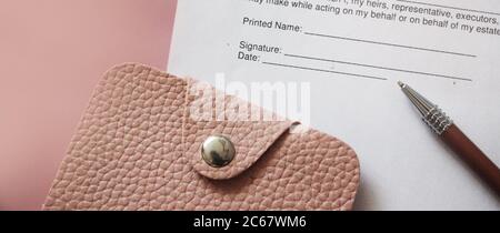 Geldbörse aus rosa Leder, Stift und Vereinbarung mit Platz zum Unterschreiben. Geschäftskonzept Stockfoto