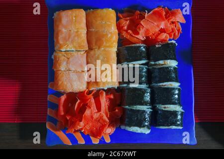 Verschiedene Sushi-Set Hintergrund. Verschiedene Sushi-Rollen auf dem Tisch auf Tellern. Nahaufnahme. Stockfoto