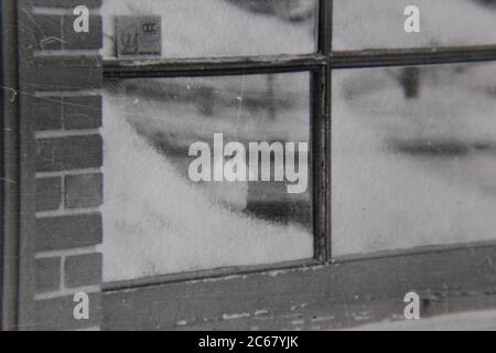 Feine 70er Jahre Vintage schwarz-weiß Lifestyle-Fotografie von einem Modell Schaufensterpuppe Blick aus dem Fenster. Stockfoto