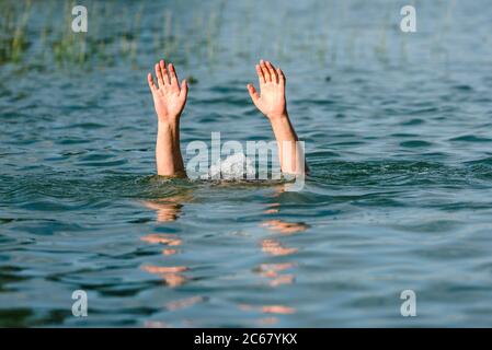 Hände ragen aus dem Wasser, um eine ertrinkende Person darzustellen Stockfoto