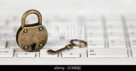 Internet-Datenschutz, Web-Sicherheitskonzept, Gold Vorhängeschloss und Schlüssel auf einem weißen Computer Laptop-Tastatur. Webbanner. Stockfoto