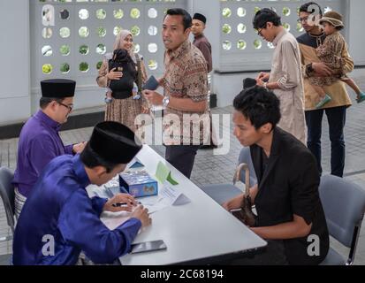 Muslim, der das obligatorische Zakat (Almosengeben) während der Eid-Feier, Tokio, Japan, bezahlt Stockfoto