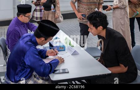 Muslim, der das obligatorische Zakat (Almosengeben) während der Eid-Feier, Tokio, Japan, bezahlt Stockfoto