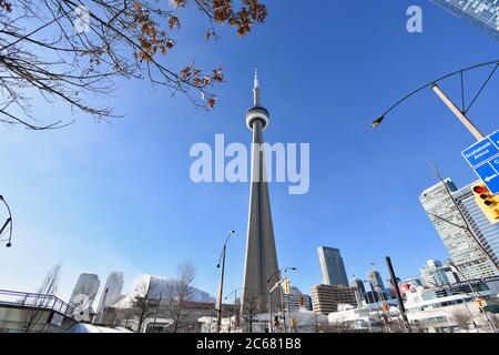 Blick auf den CN Tower von der Lower Simcoe Street an einem klaren Wintermorgen. Das Metro Convention Center und Ripley's Aquarium sind zu sehen. Stockfoto