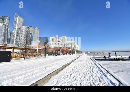 Der Waterfront Trail am Harbour Front Centre in Toronto. Schnee liegt auf dem Boden und Lake Ontario hat im Winterwetter zugefroren. Stockfoto