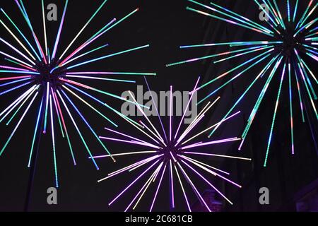 Leichte Kunstwerke in einem Burst-Muster mit schwarzem Hintergrund beim Toronto Light Festival im Historic Distillery District während einer Winternacht. Stockfoto