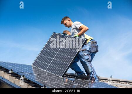 Installation von Solar photovoltaik Panel System. Solar Panel Techniker die Installation von Sonnenkollektoren auf dem Dach. Alternative Energie ökologische Konzept. Stockfoto
